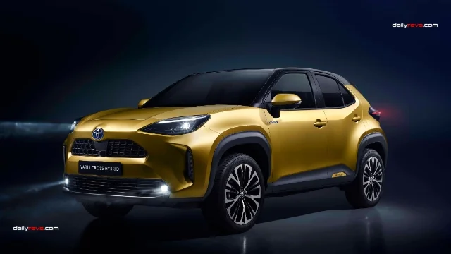 Toyota Yaris Cross Hybrid – Gold Exterior Front Three-Quarter View Gold Toyota Yaris Cross Hybrid photographed in a dark studio, showing its front three-quarter design, LED headlights, black grille, contrasting roof and multi-spoke alloy wheels.