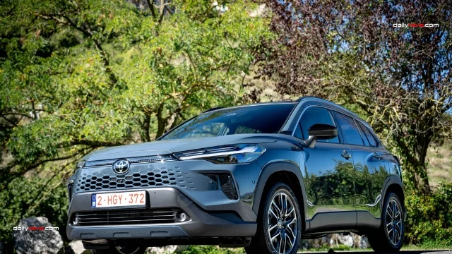 2026 Toyota Corolla Cross European Version – Blue Exterior Front Three-Quarter View 2026 Toyota Corolla Cross European facelift in metallic blue, photographed from the front three-quarter angle with a body-coloured honeycomb grille, LED headlights and alloy wheels.