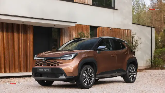 2027 Toyota Yaris Cross Facelift Concept – Bronze Exterior Front Three-Quarter View 2027 Toyota Yaris Cross facelift concept in metallic bronze, showing its redesigned honeycomb grille, slim LED headlights, black roof and front three-quarter exterior styling.